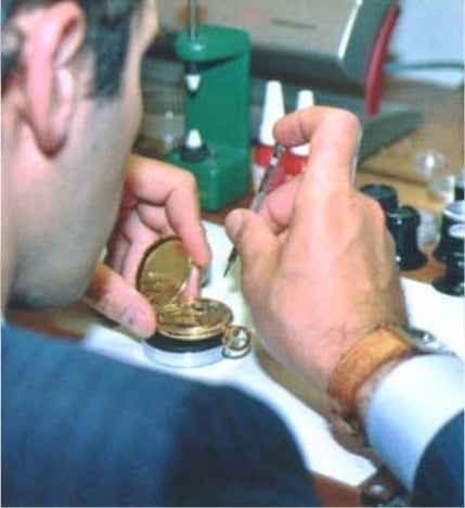 Denis Asch en train de travailler sur un mécanisme d'horlogerie